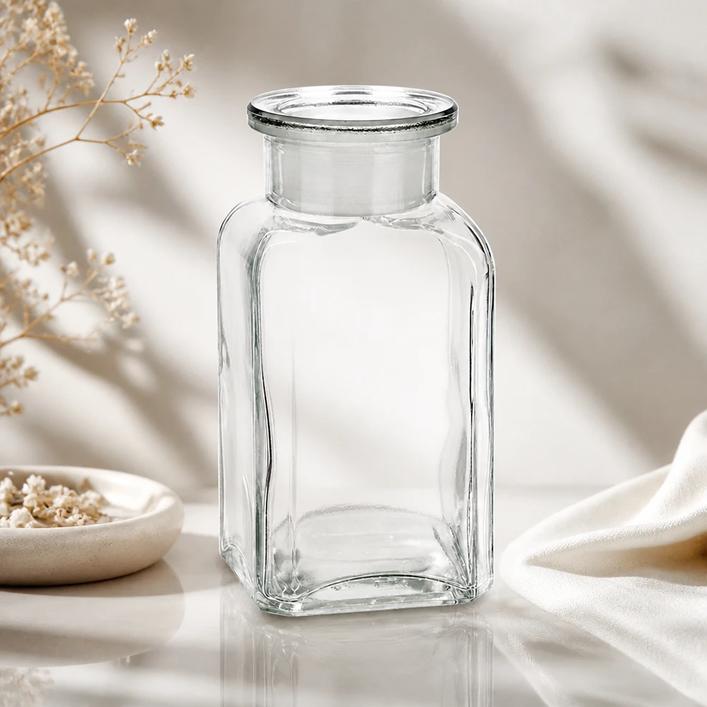 Vierkantflasche 100ml klar Weithals Glasstopfen Klare 100ml Vierkantflasche mit Glasverschluss luftiger Hintergrund mit getrockneten Wiesenblumen